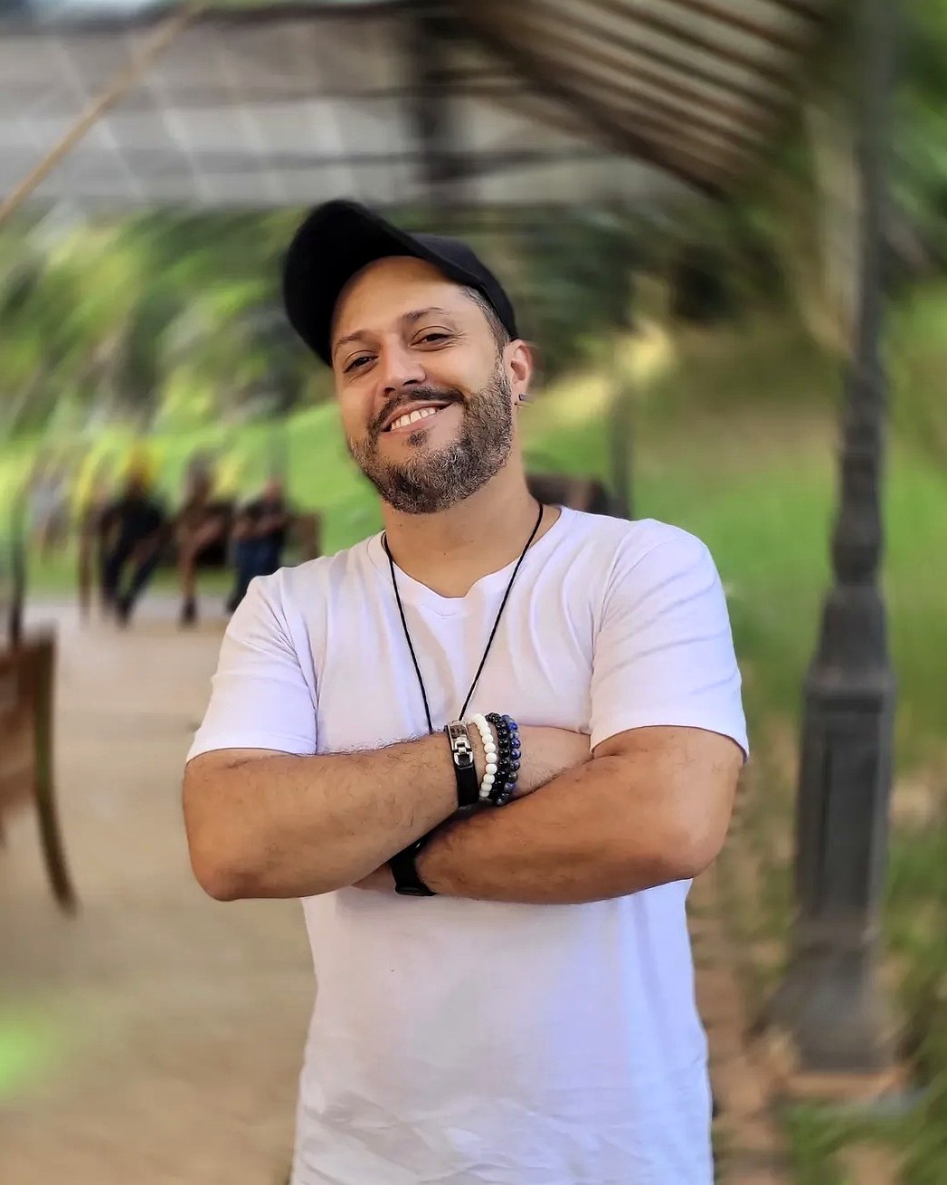 Thiago Pimenta, cantor multiestilo de Belo Horizonte, sorrindo de boné e camiseta branca
